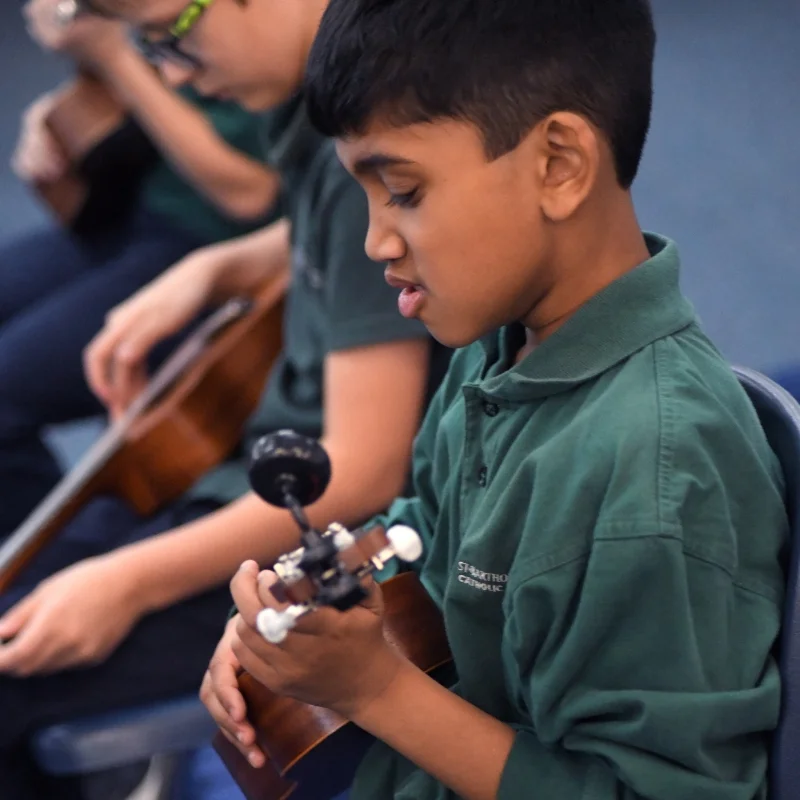 student playing a ukulele